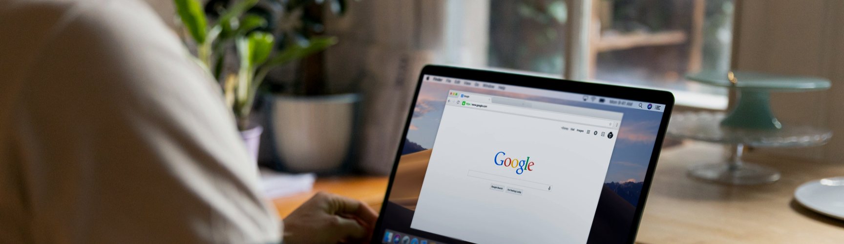 Person in coffee shop on Google on laptop