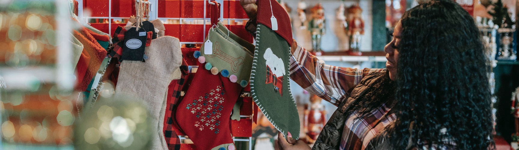 Shopper holding Christmas stockings for sale in store