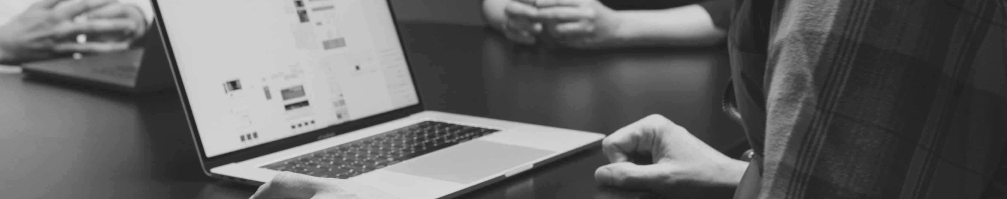 Laptop and employees in a meeting
